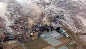 A tsunami carries buildings across waters in Kamaishi city port.