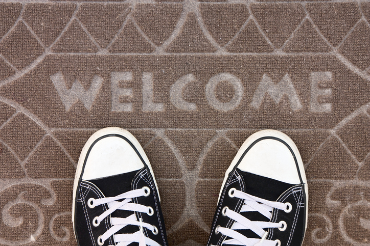 Welcome mat with black and white sneakers